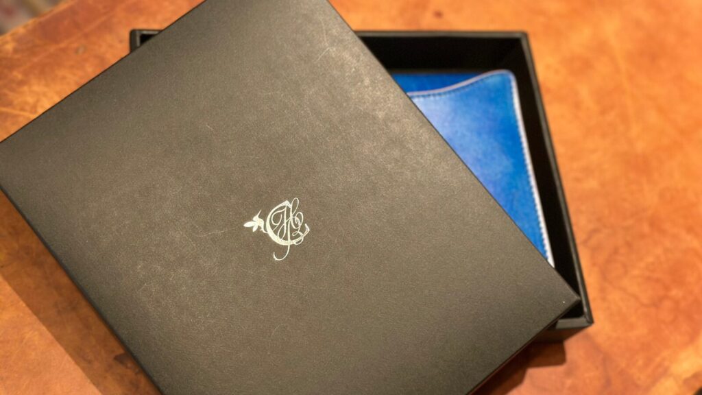 オリジナルボックスにブックカバー「OLIVE」を収納した様子。黒色のボックスに銀の箔押しでロゴを入れた特製仕様。