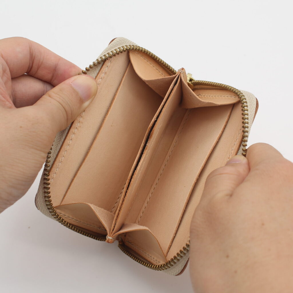 中はセンターポケットとサイドにフリーポケットが広がる構造。両端にはカードの収納にも便利な仕切り付き。