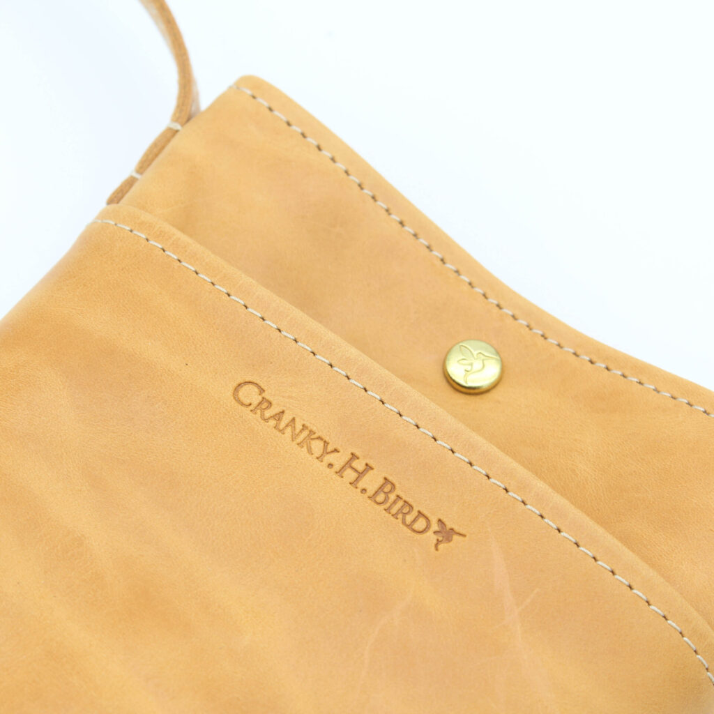 フロントポケットとメインポケットの2箇所収納。可愛いハチドリボタンも特徴。