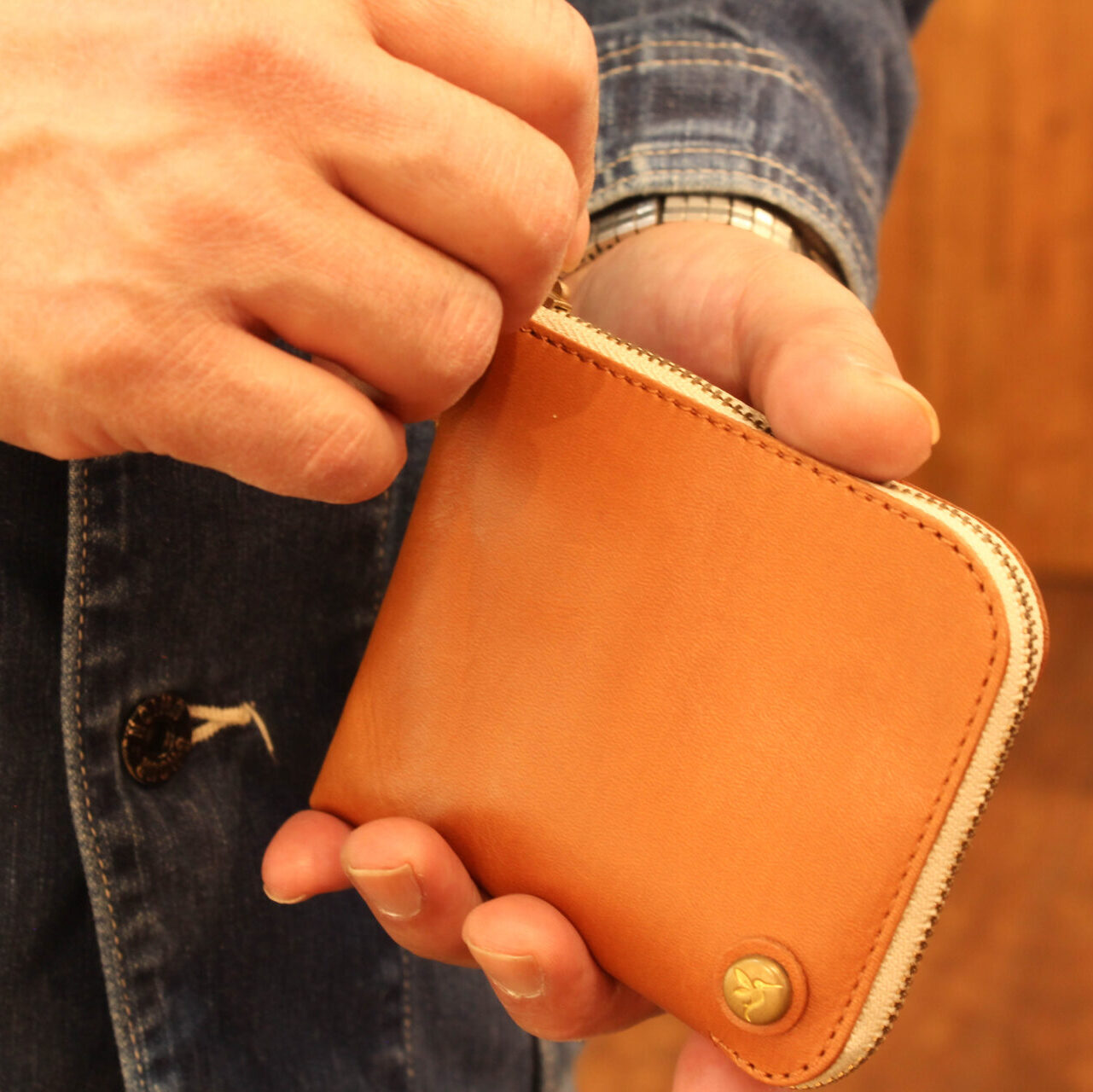 ミニ財布COOPERを手に持った様子。男性なら手のひらに収まるぐらいの大きさ